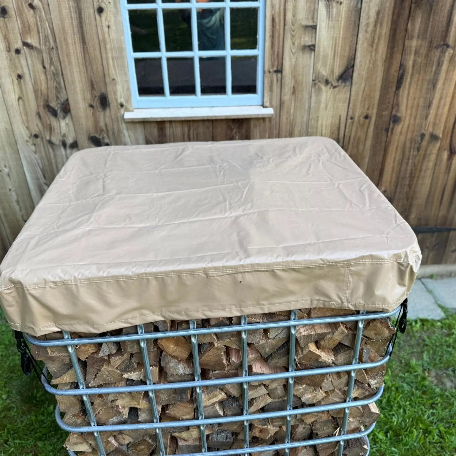 Waterprooof cordwood cover on a IBC tote filled with firewood placed outside