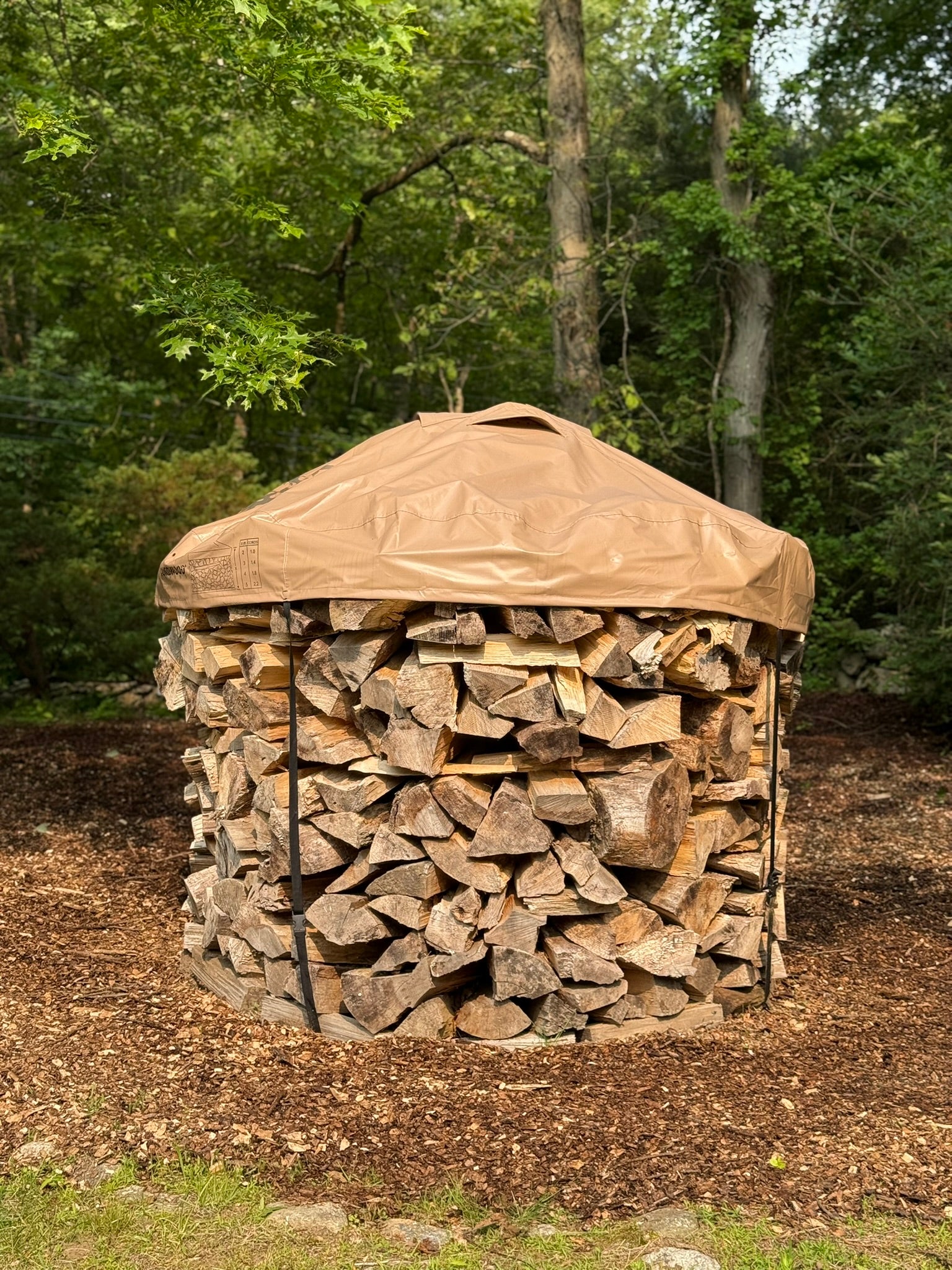 6ft diameter round stack of firewood neatly stacked with a cordwood cover
