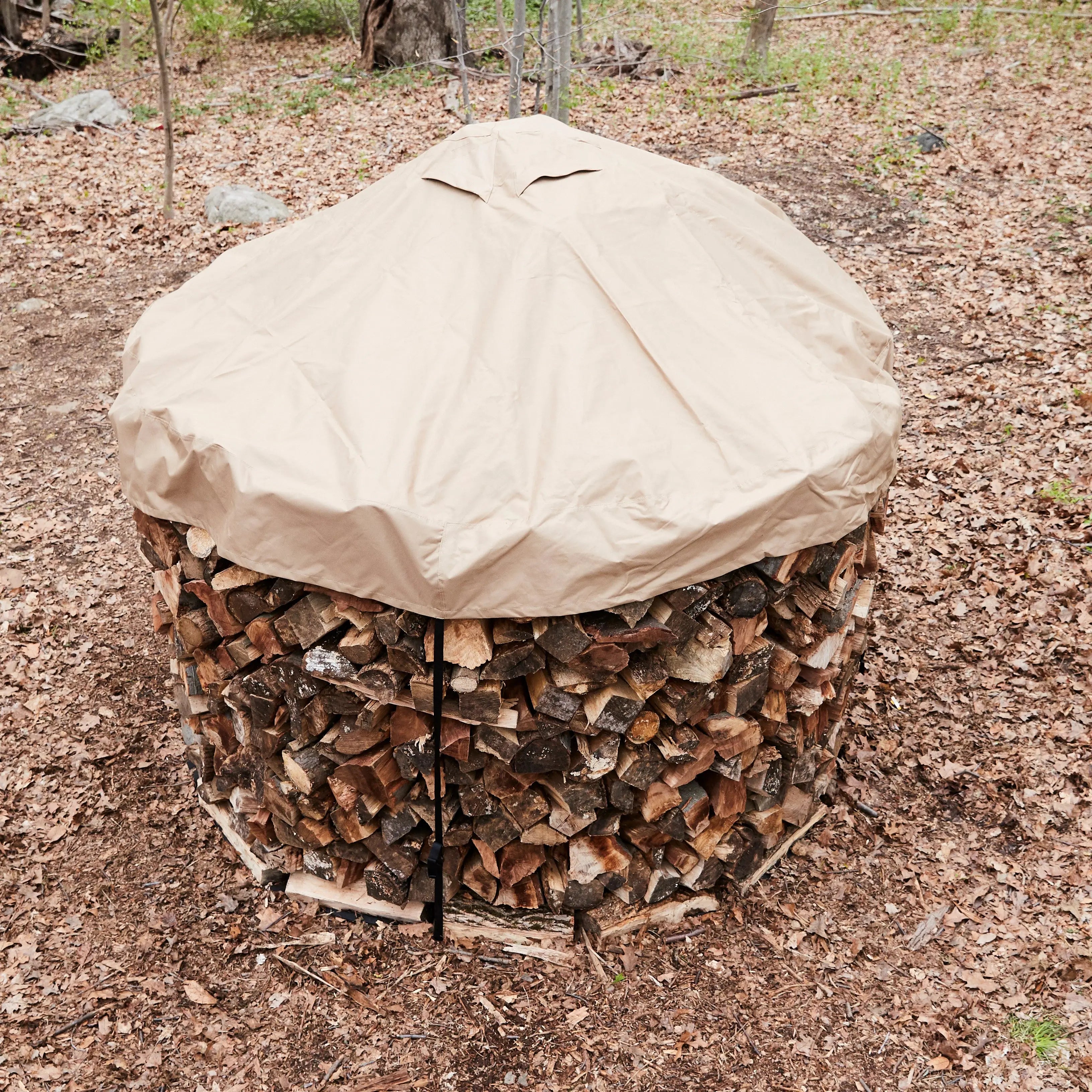 FIrewood neatly stacked in a round woodpile using a 8ft Cordwood Covers.
