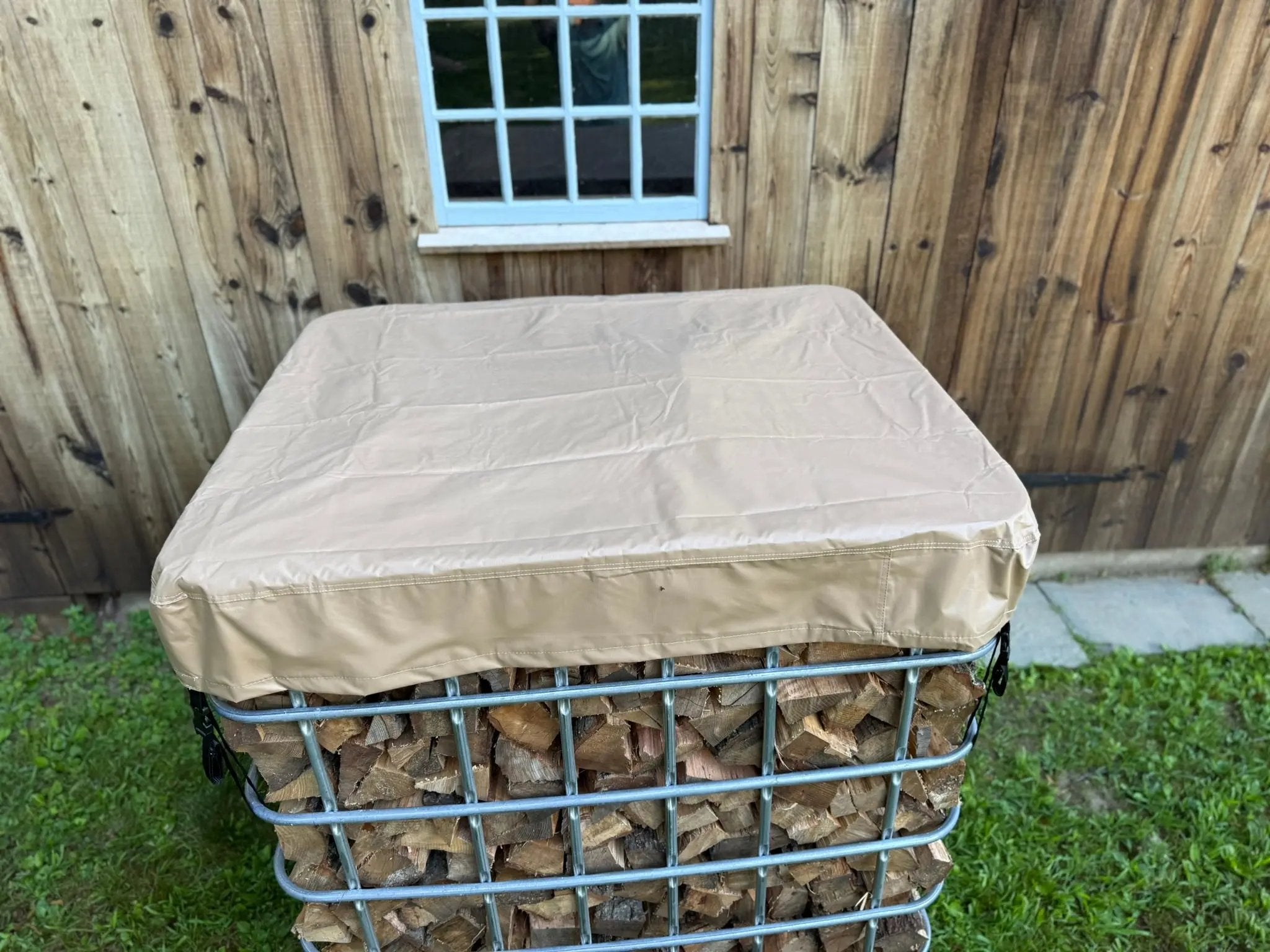 Waterprooof cordwood cover on a IBC tote filled with firewood placed outside